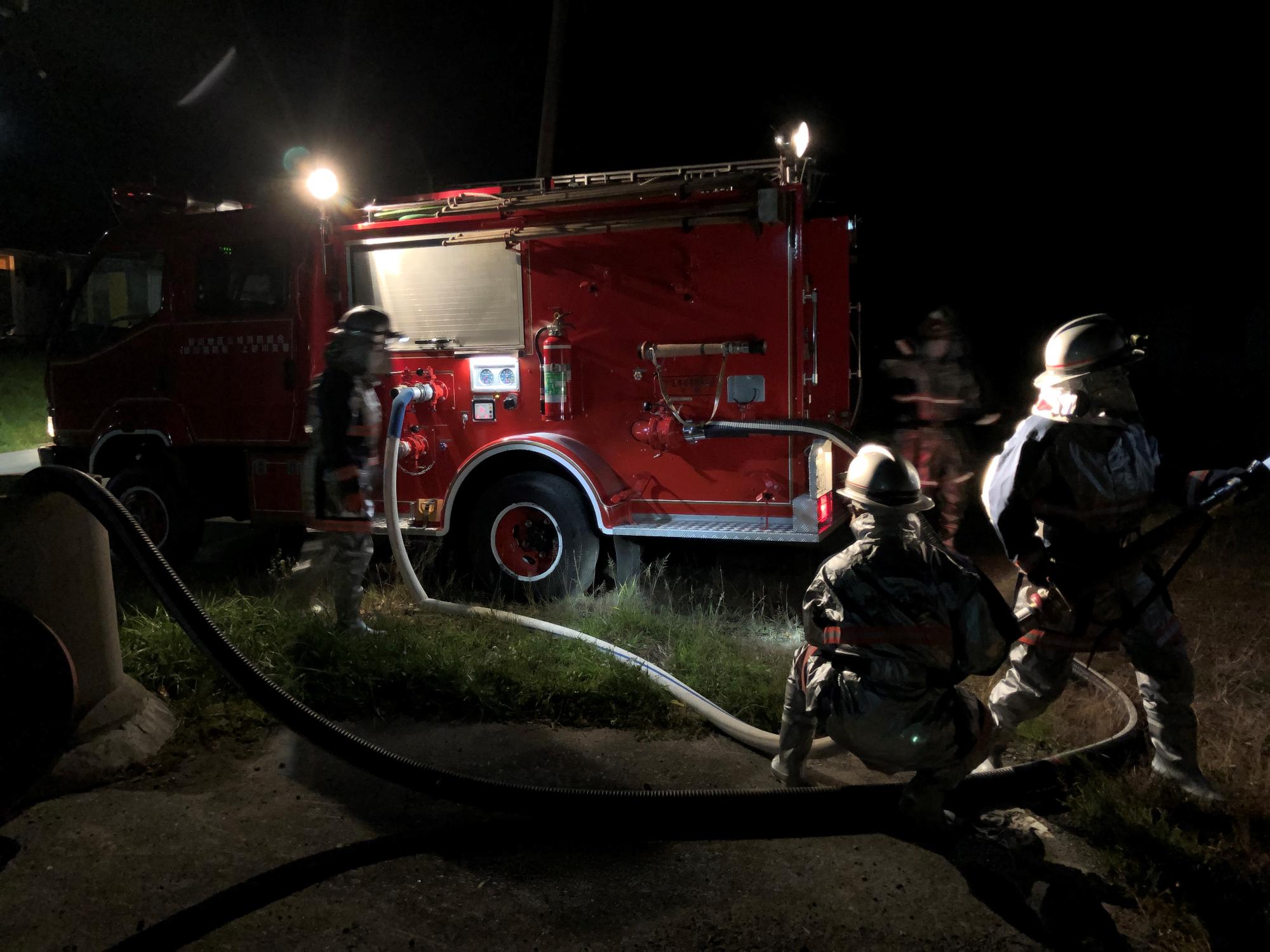 機関指定された団員が、夜間走行訓練、防火水槽を使用し揚水・放水訓練を行っている写真